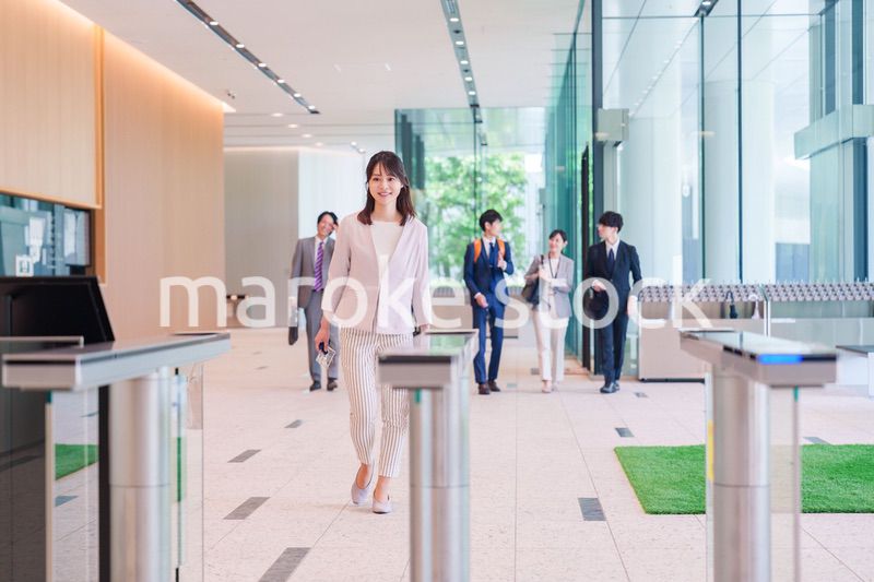 オフィスのセキュリティゲートを通るビジネスウーマン