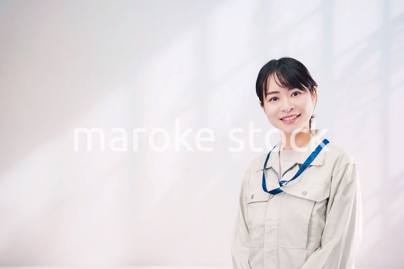 作業服を着て笑顔の若い女性（シンプル背景）
