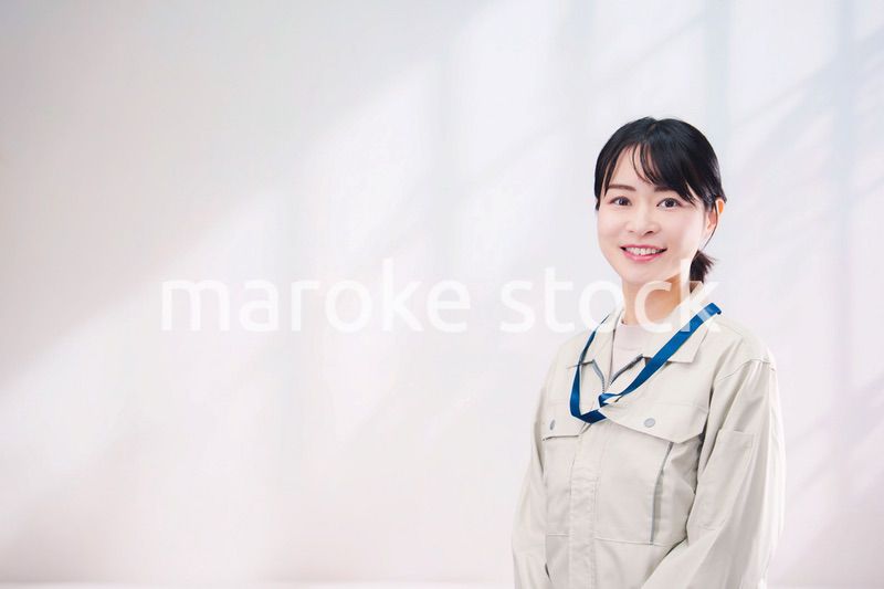 作業服を着て笑顔の若い女性（シンプル背景）