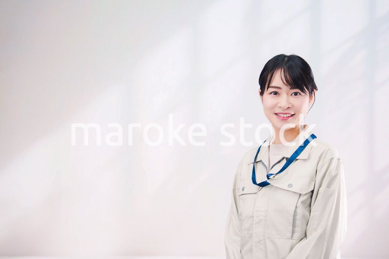 作業服を着て笑顔の若い女性（シンプル背景）