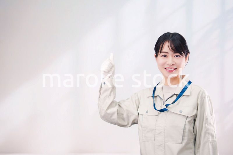 作業服を着て笑顔の若い女性（シンプル背景）