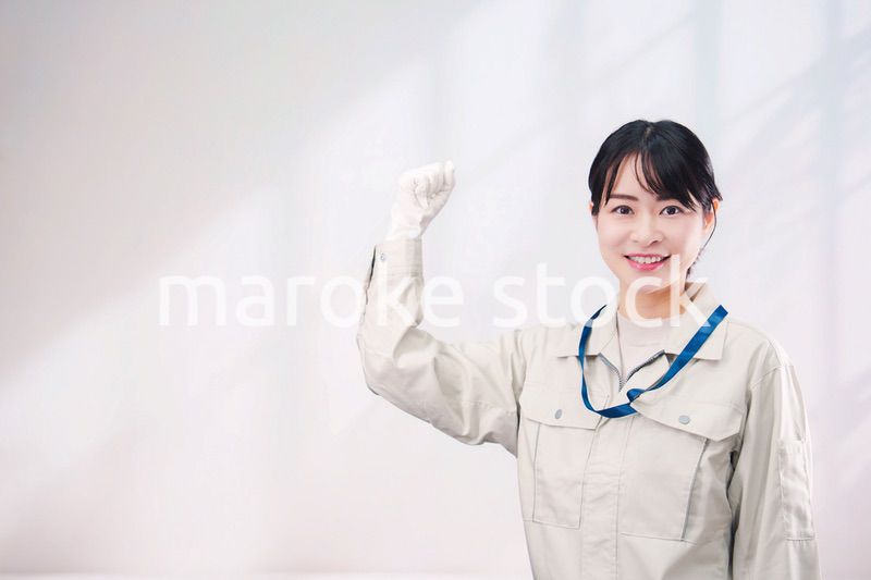 作業服を着て笑顔の若い女性（シンプル背景）