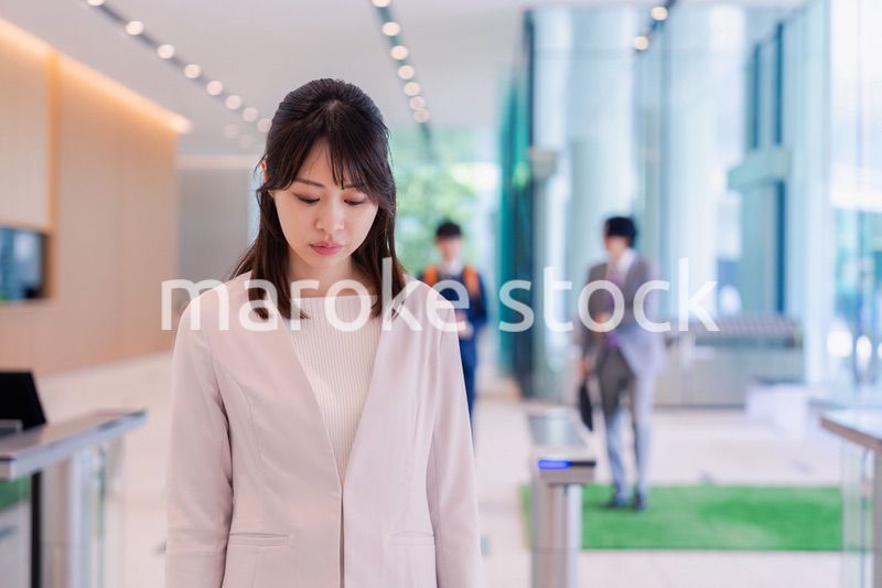 悲しい顔をしてオフィスに出社する女性