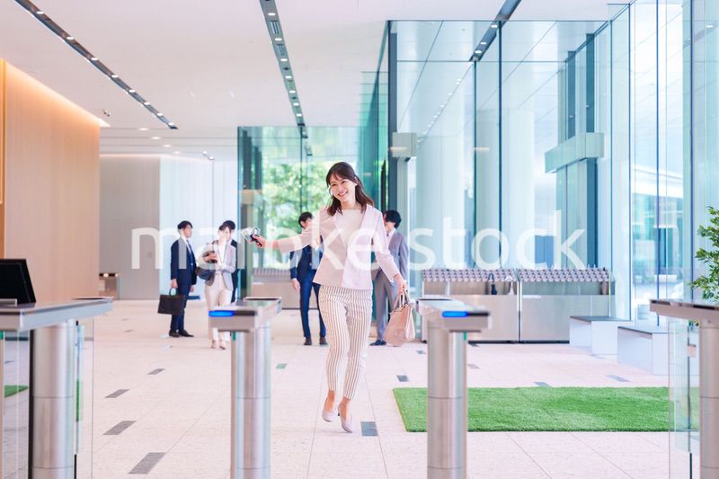 ウキウキして会社に出社する若いビジネスウーマン