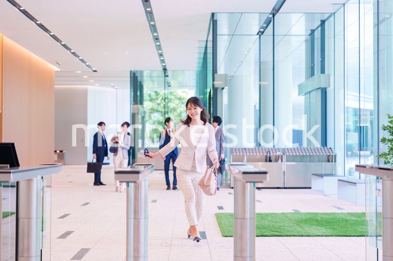 ウキウキして会社に出社する若いビジネスウーマン