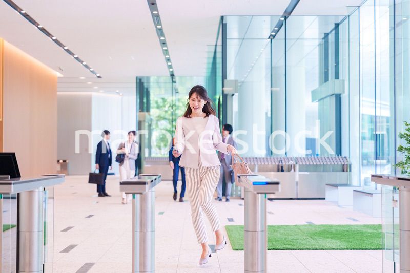 ウキウキして会社に出社する若いビジネスウーマン