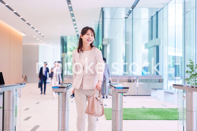 ウキウキして会社に出社する若いビジネスウーマン