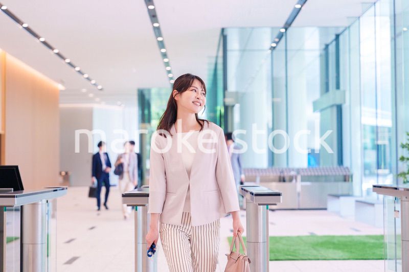 ウキウキして会社に出社する若いビジネスウーマン