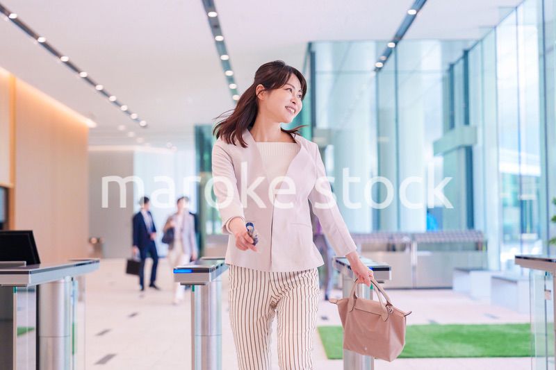 ウキウキして会社に出社する若いビジネスウーマン