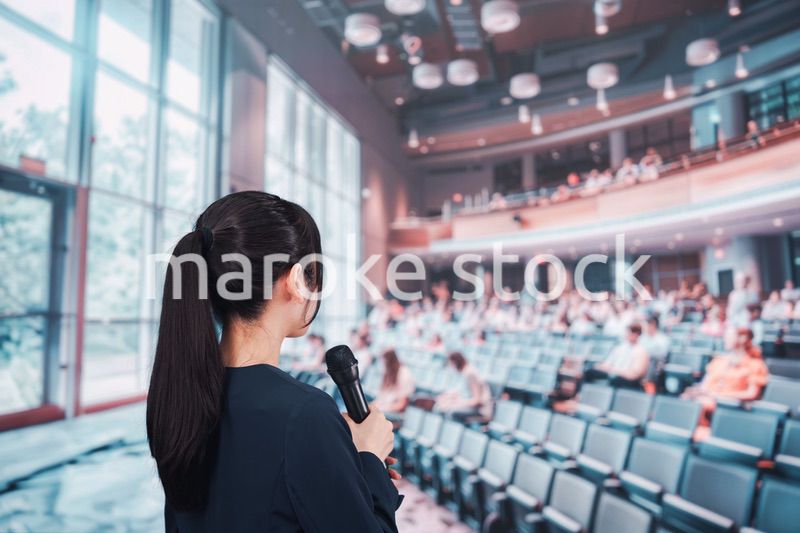 ホールで司会をする若い女性