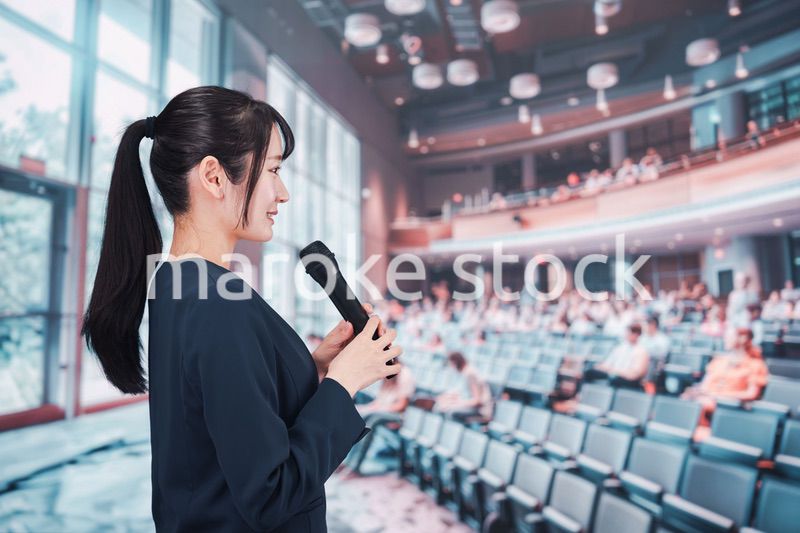 ホールで司会をする若い女性