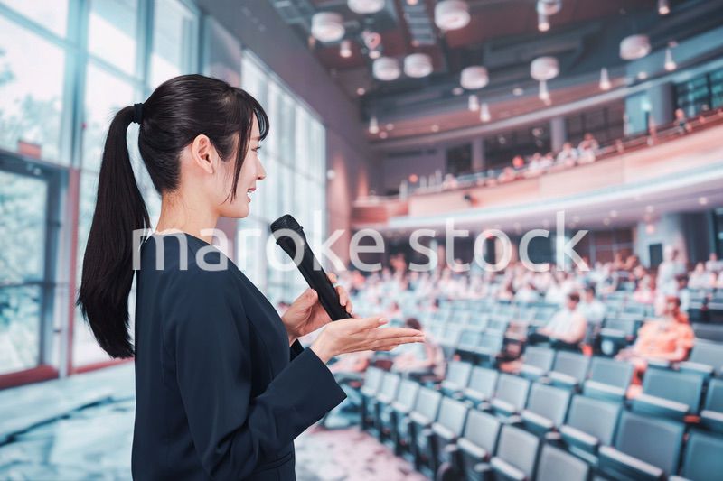 ホールで司会をする若い女性