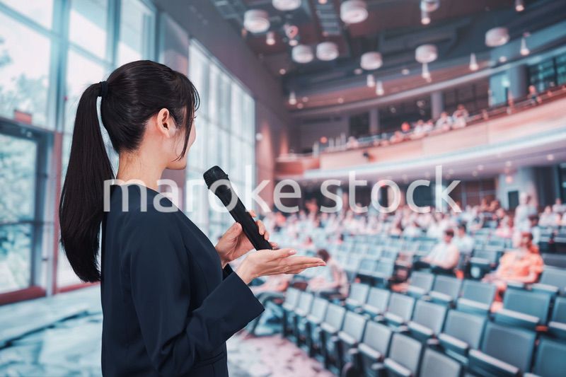 ホールで司会をする若い女性