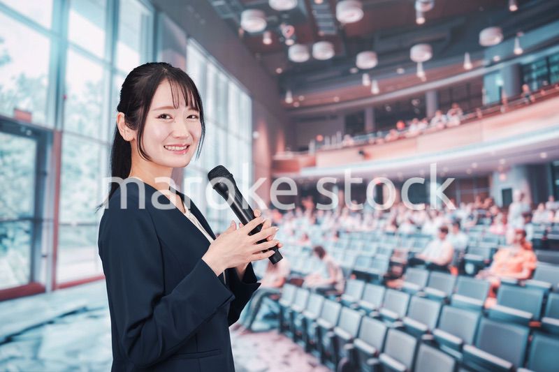 ホールで司会をする若い女性