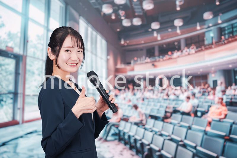 ホールで司会をする若い女性