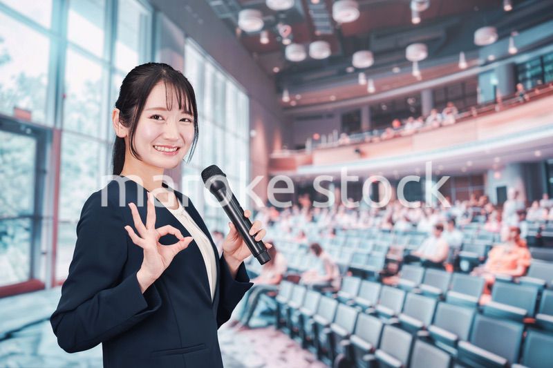 ホールで司会をする若い女性