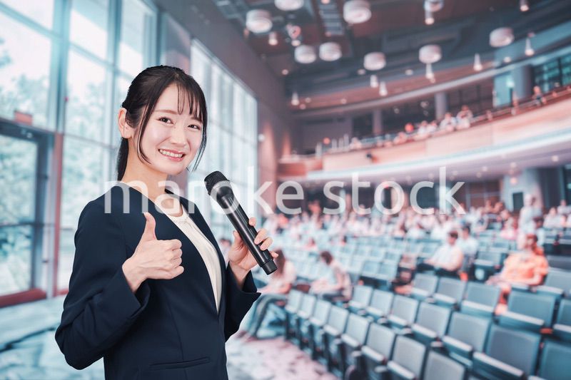 ホールで司会をする若い女性