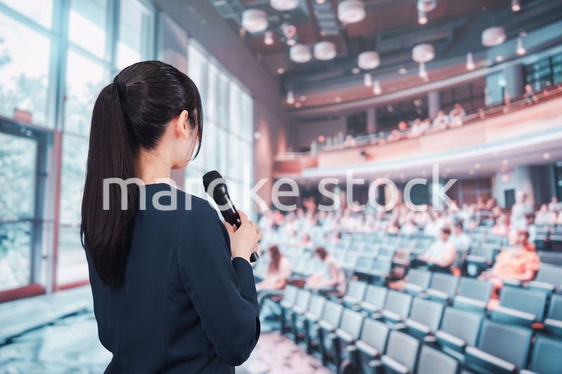 ホールで司会をする若い女性