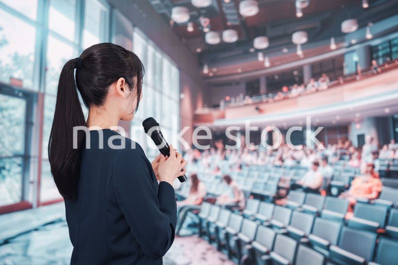 ホールで司会をする若い女性