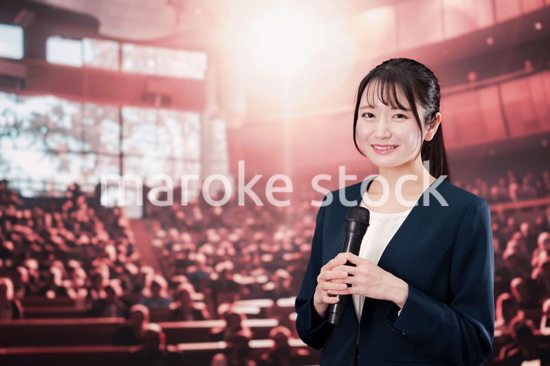 大勢の聴衆の前で話す女性