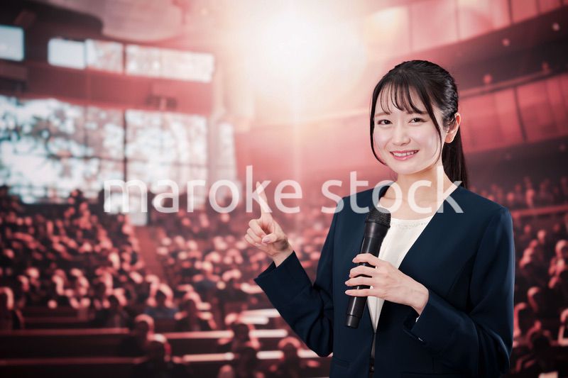 大勢の聴衆の前で話す女性