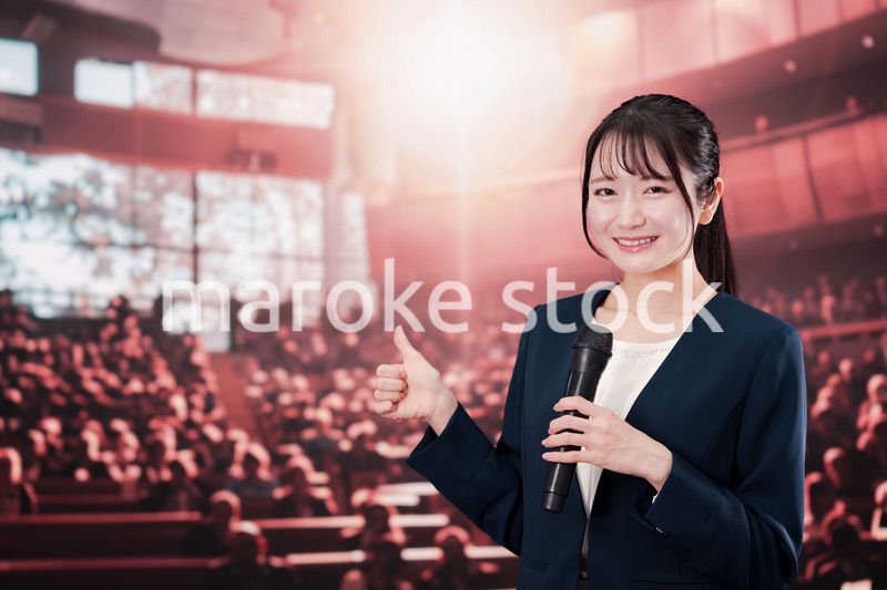 大勢の聴衆の前で話す女性