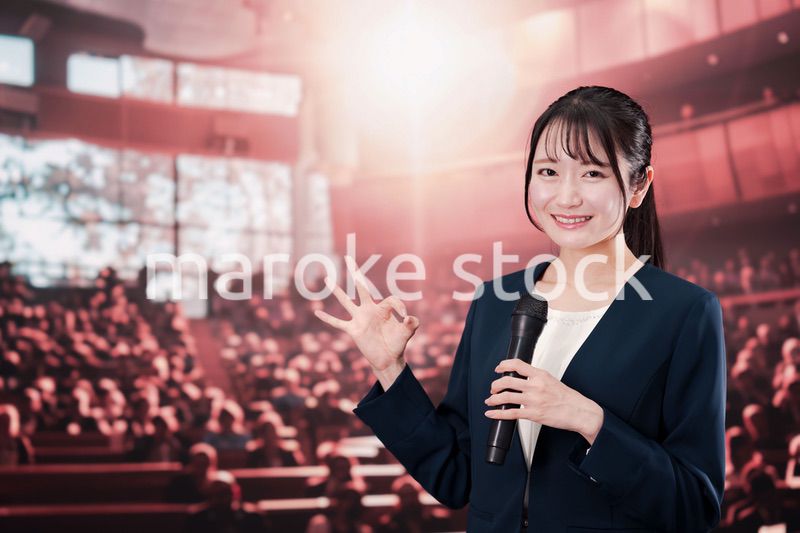 大勢の聴衆の前で話す女性