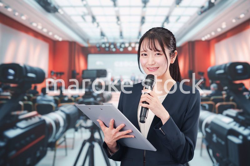 記者会見場からレポートをする女性のアナウンサー