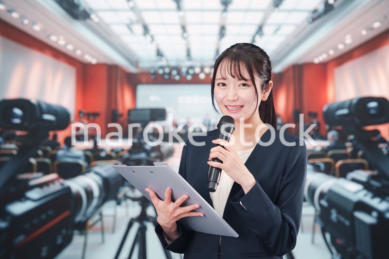 記者会見場からレポートをする女性のアナウンサー