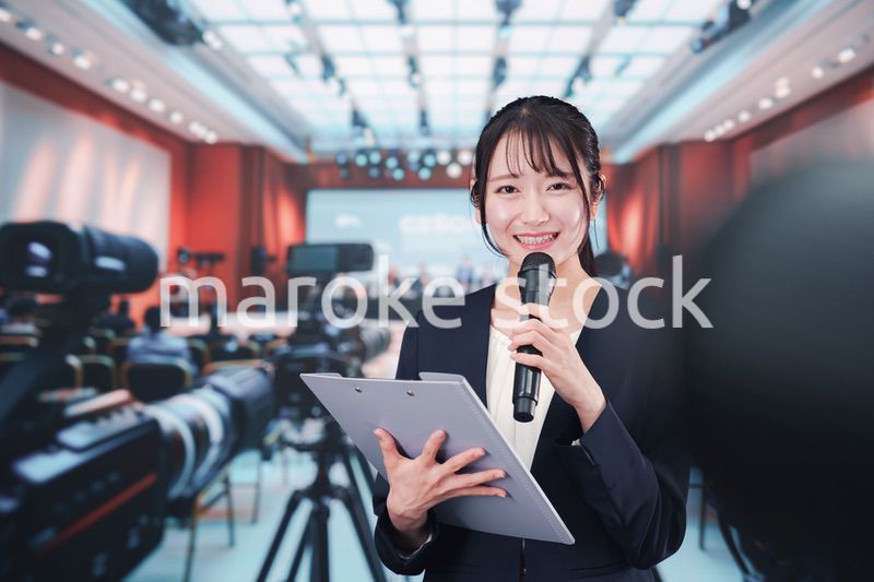 記者会見場からレポートをする女性記者