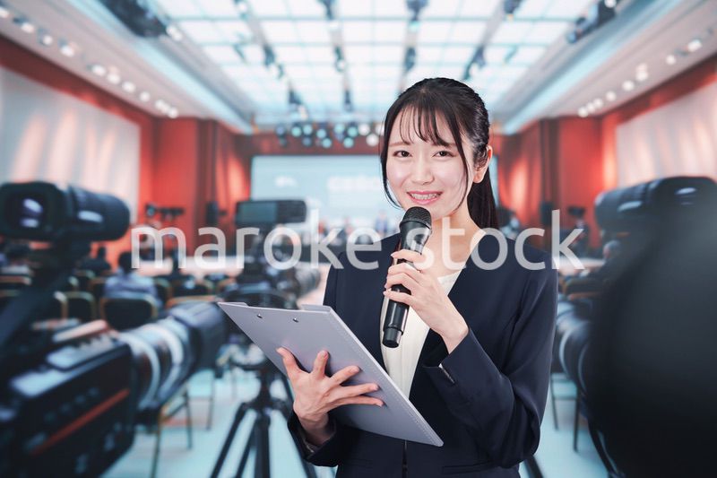 記者会見場からレポートをする女性記者