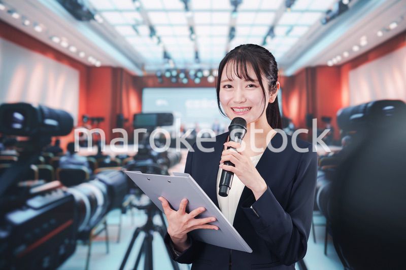 記者会見場からレポートをする女性記者