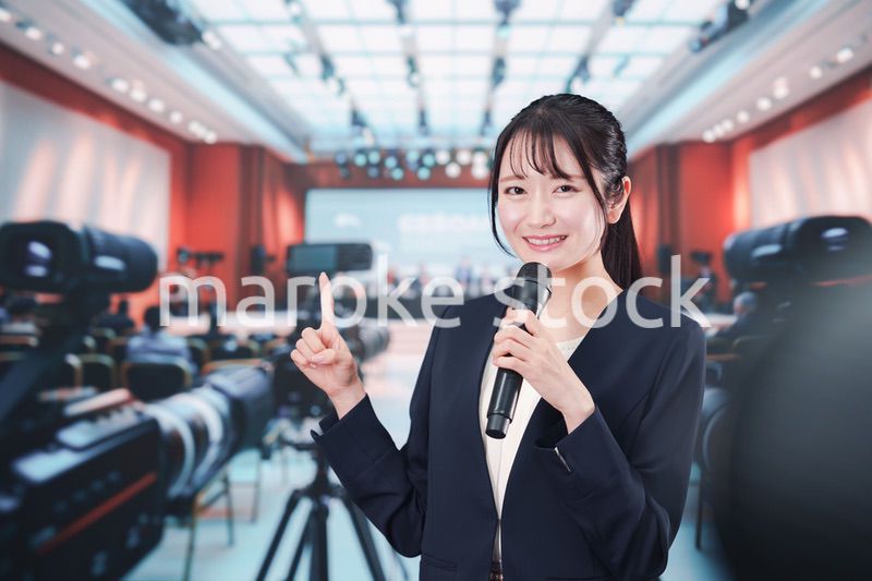 記者会見場からレポートをする女性記者