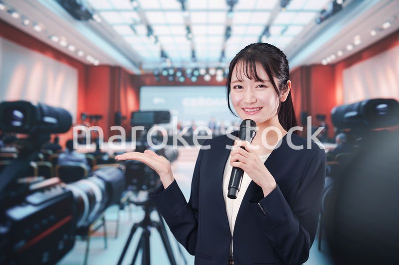 記者会見場からレポートをする女性記者