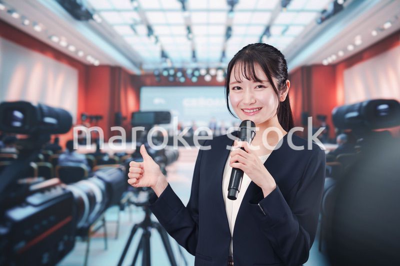 記者会見場からレポートをする女性記者