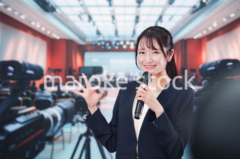 記者会見場からレポートをする女性記者