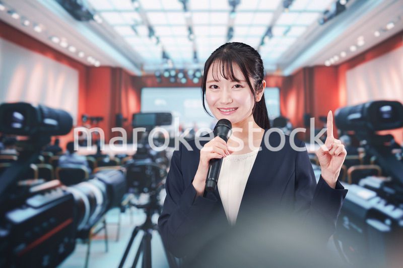 記者会見場からレポートをする女性記者