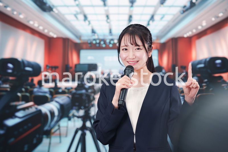 記者会見場からレポートをする女性記者