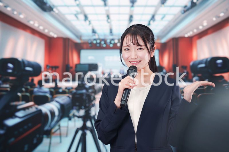 記者会見場からレポートをする女性記者