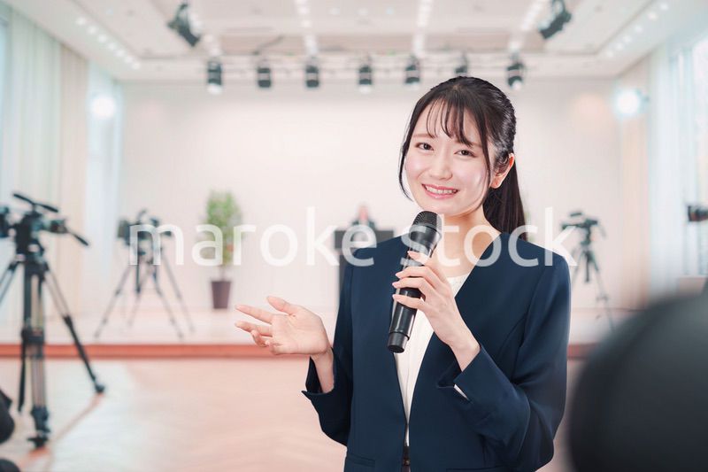 記者会見場からレポートをする女性のアナウンサー