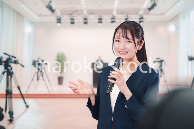 記者会見場からレポートをする女性のアナウンサー
