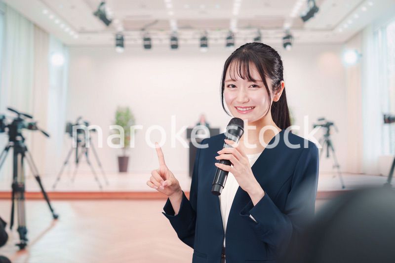 記者会見場からレポートをする女性のアナウンサー
