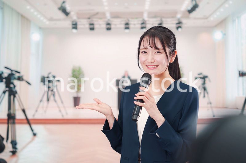 記者会見場からレポートをする女性のアナウンサー