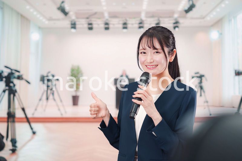 記者会見場からレポートをする女性のアナウンサー