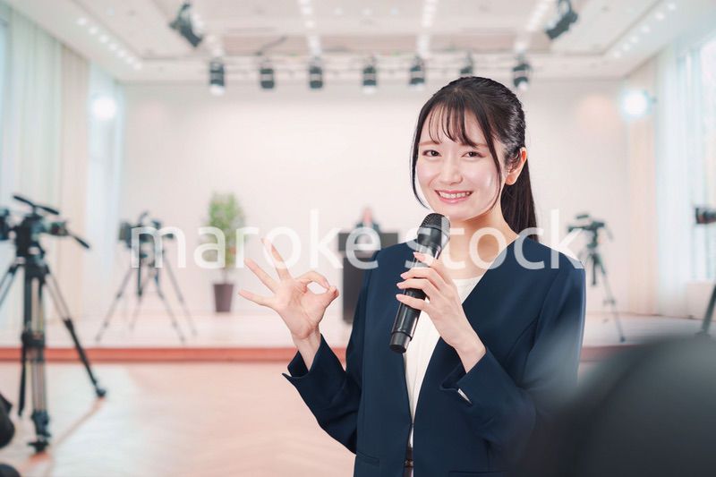 記者会見場からレポートをする女性のアナウンサー