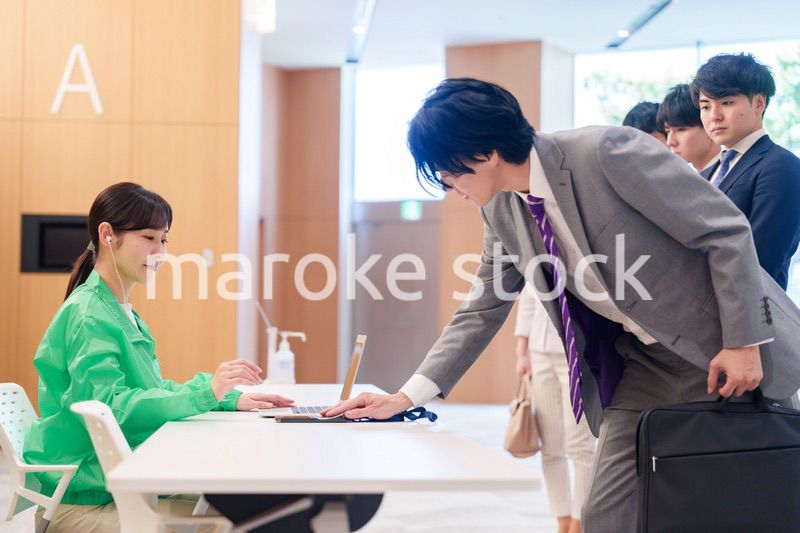 カンファレンスの受付スタッフと参加者