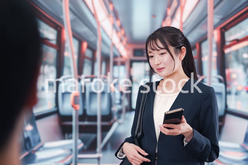 バスに乗って通勤をする若い女性