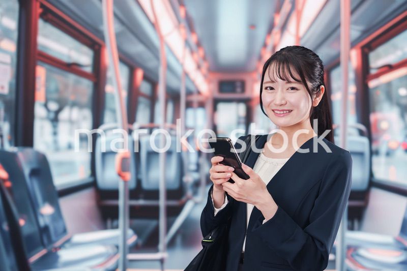 バスに乗って通勤をする若い女性