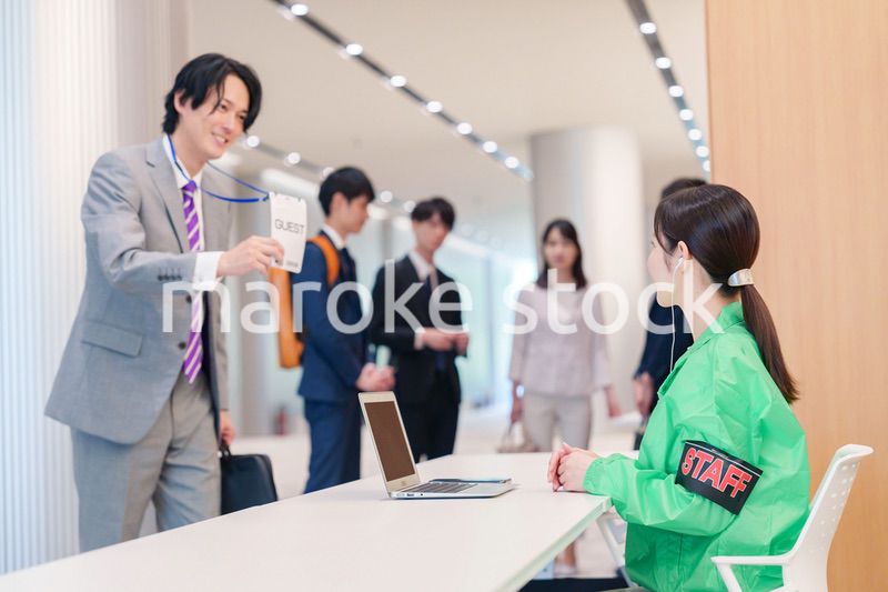 カンファレンスの受付スタッフと参加者