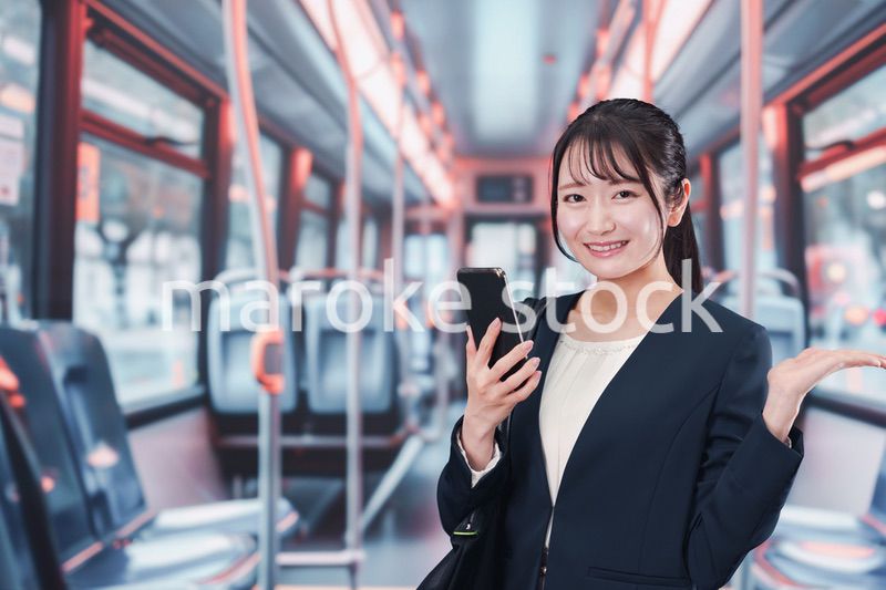 バスに乗って通勤をする若い女性